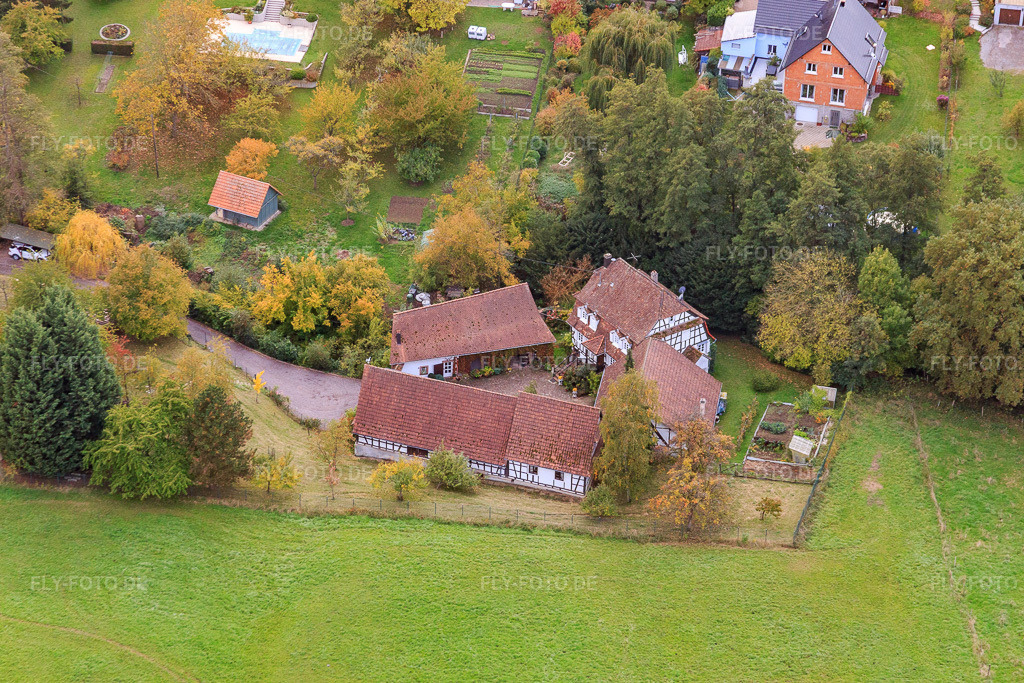 Luftbild: Fachwerkgehöft am Hausauerbach in Oberhoffen-lès-Wissembourg im Bundesland Bas-Rhin in Frankreich. – Foto: IMG_084596.jpg vom 23.10.2015 durch Werner Riehm/FLY-FOTO.de – Auflösung des Originals: 5340 x 3560 px