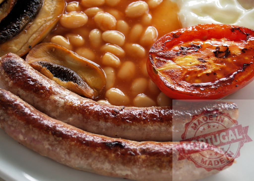 Full English breakfast with sausages, beans, tomato, mushrooms | Plate showing a delicious English breakfast with grilled sausages, baked beans, tomato, and mushrooms - Realized with Pictrs.com
