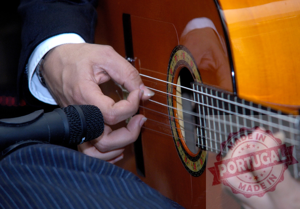 Musician playing classical guitar strings during live music performance | Musician hands plucking strings on an acoustic guitar with a close-up microphone - Realized with Pictrs.com