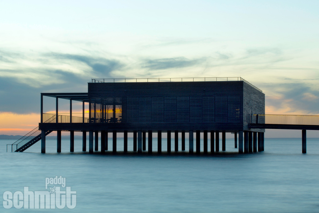 Badehaus am Kaiserstrand bei Lochau am Bodensee | Das Badehaus am Kaiserstrand bei Lochau liegt idyllisch direkt am Bodensee und verbindet historische Atmosphäre mit der Weite des Sees. Die besondere Architektur vor der ruhigen Wasserfläche macht diesen Ort zu einem stimmungsvollen und charaktervollen Motiv. - Realisiert mit Pictrs.com