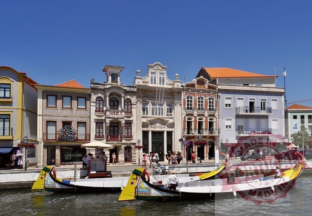 Aveiro city canal with traditional moliceiros boats. Aveiro - Portugal | Aveiro, Portugal, featuring two moliceiro boats on a canal passing colorful Art Nouveau architecture - Realized with Pictrs.com