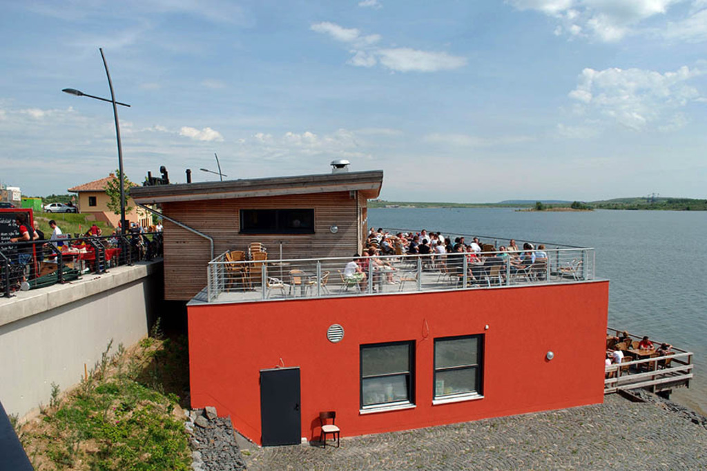 Foto: Leipzig - Markkleeberger See - Seepromenade und Strandhaus am Markkleeberger See | Das Team hinter BILDLEXIKON LEIPZIG bündelt historische wie aktuelle Informationen über die Stadt Leipzig in Text und Bild auf einer Plattform und stellt diese der interessierten Öffentlichkeit zur Verfügung.