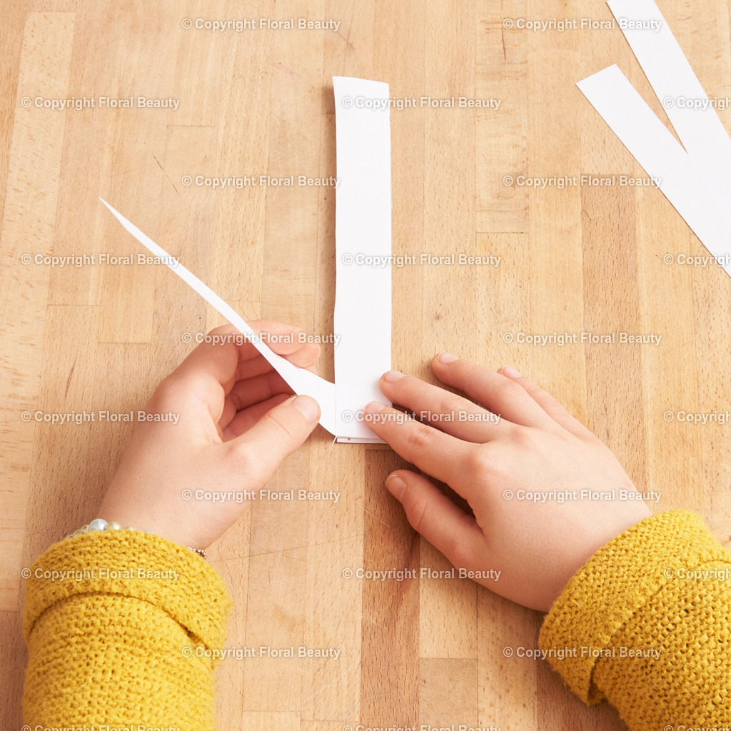 Hexentreppe aus Papier basteln | Papier in 2 cm breite Streifen schneiden. Mit Kleber rechtwinklig fixieren. Abwechselnd Streifen über Streifen legen und andrücken. Abschließend zusammenkleben. - Realisiert mit Pictrs.com