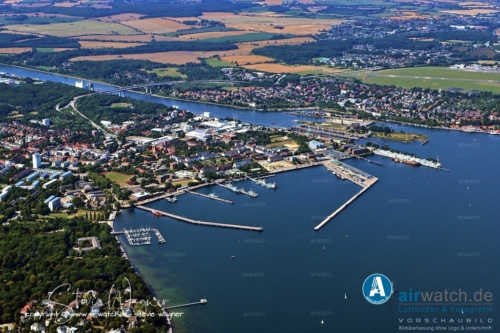Luftbild Kiel Hafen - Der moderne Marinehafen (2026) Marinestützpunkt Tirpitzhafen | Der moderne Marinehafen (2026) Marinestützpunkt Tirpitzhafen: Heute ist der Marinestützpunkt Kiel in der Wik die Heimat wichtiger Verbände wie der Einsatzflottille 1 und zahlreicher Unterstützungsboote. Internationale Bedeutung: Auch 2026 dient der Hafen als Drehscheibe für große Manöver. Im Januar 2026 findet beispielsweise die Marineübung SQUADEX 2026 unter Extrembedingungen in der Ostsee statt.