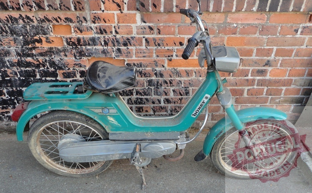 Vintage Boxer Moped Parked Against Weathered Brick Wall | Old, slightly rusty Boxer moped parked against a weathered brick wall, evoking a sense of nostalgia - Realisiert mit Pictrs.com