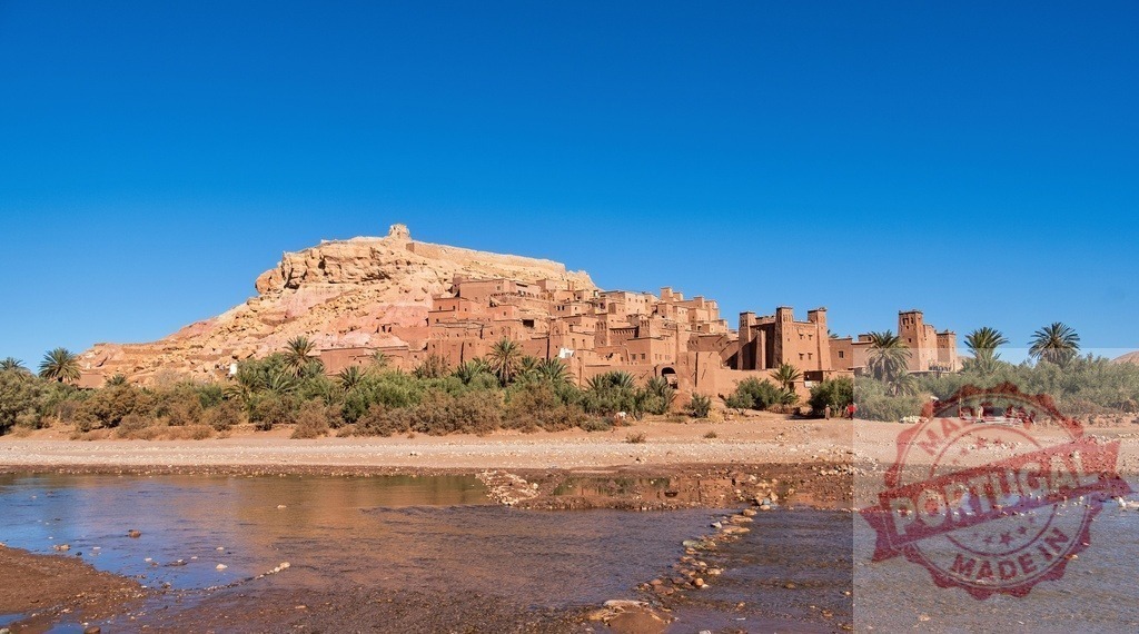 Ait Benhaddou reflecting in the river under blue sky, Morocco | Ait Benhaddou Ksar, a UNESCO World Heritage Site, reflecting in the river under blue sky, Morocco - Realisiert mit Pictrs.com