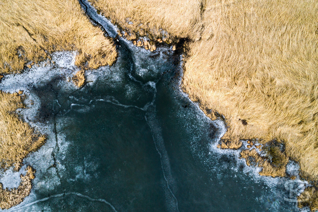Zugefrorener See im Allgäu – Drohnenaufnahme von Eisstrukturen am Ufer | Beeindruckende Luftaufnahme eines vollständig zugefrorenen Sees im Allgäu. Die Drohnenfotografie zeigt faszinierende Eisstrukturen, Uferbereiche und natürliche Wintermuster aus der Vogelperspektive – einzigartige Winterlandschaft von oben. - Realisiert mit Pictrs.com