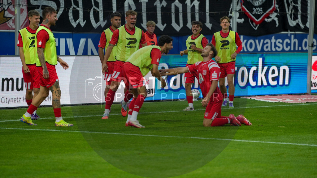 Fußball, Herren, Saison 2025/2026, Regionalliga Nordost, 5. Spieltag, Hallescher FC vs. FSV 63 Luckenwalde, Dienstag 26.08.2025, Leuna-Chemie-Stadion Halle, | Fußball, Herren, Saison 2025/2026, Regionalliga Nordost, 5. Spieltag, Hallescher FC vs. FSV 63 Luckenwalde, Dienstag 26.08.2025, Leuna-Chemie-Stadion Halle, Im Bild: Max Kulke (r. Halle) jubelt mit den Wechselspielern des Halleschen FC um Serhat Polat (l.) über seinen Treffer zum 3:0. - Realisiert mit Pictrs.com