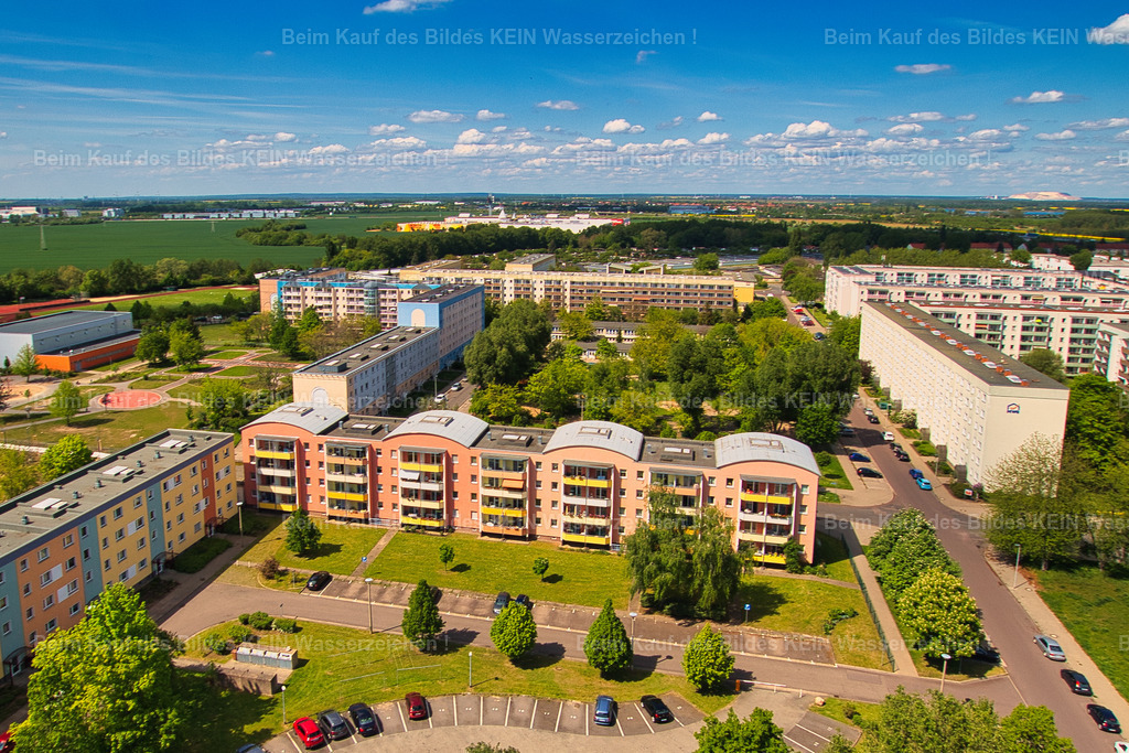 Magdeburg-Pablo-Picasso-Helene-Weigel-Kannenstieg-Nord-2873 | Blick aus der Luft auf einen ehemaligen sechsgeschossigen Plattenbau in der Picassostraße im Magdeburger Kannenstieg. Das Gebäude wurde inzwischen auf vier Geschosse zurückgebaut und erhielt eine auffällige rosafarbene Fassade. Der Rückbau zeigt beispielhaft, wie sich viele Wohngebiete des Kannenstiegs nach der Wende verändert haben. Aus den großmaßstäblichen Plattenbauten der DDR-Zeit wurden durch Rückbau, Sanierung und neue Fassadengestaltung teilweise völlig andere Gebäude. Die ursprüngliche Struktur bleibt dabei trotzdem erkennbar.Für mich ist dieses Motiv allerdings mehr als ein Beispiel für Stadtentwicklung. Ich habe viele Jahre meines Lebens im Kannenstieg und genau in diesem Block verbracht. Die Plattenbauten sind deshalb ein Teil meiner eigenen Geschichte und meiner Erinnerungen an Magdeburg .Vielleicht liegt genau darin auch ein Stück der Erklärung für den Namen meiner Seite „Magdeburger Platte“. Der Begriff beschreibt nicht nur eine bestimmte Architektur, sondern für mich auch ein Stück Heimat, Lebenszeit und persönliche Erinnerung. Heute sieht das Gebäude anders aus als damals. Aber gerade deshalb ist es für meine fotografische Zeitreise interessant: Man kann an einem einzigen Haus ablesen, wie sich Magdeburg – und auch meine eigene Verbindung zu dieser Stadt – verändert hat. - Realisiert mit Pictrs.com