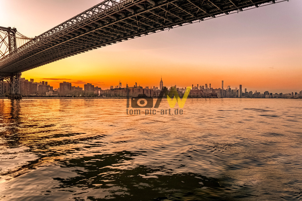 Fantastischer Sonnenuntergang in New York mit Brücke---USA | Das Bild zeigt die Manhattan Bridge bei Sonnenuntergang , mit Blick auf die Skyline von Lower Manhattan. Hier sind einige Details über die Brücke:Sie ist eine Hängebrücke, die Lower Manhattan und Downtown Brooklyn über den East River verbindet. Die Brücke wurde 1909 eröffnet und war die dritte der großen Hängebrücken über den East River, nach der Brooklyn und der Williamsburg Bridge. Sie ist bekannt für ihre robuste Industriestruktur und bietet separate Wege für Autos, U-Bahnen, Fußgänger und Radfahrer.  - Realisiert mit Pictrs.com