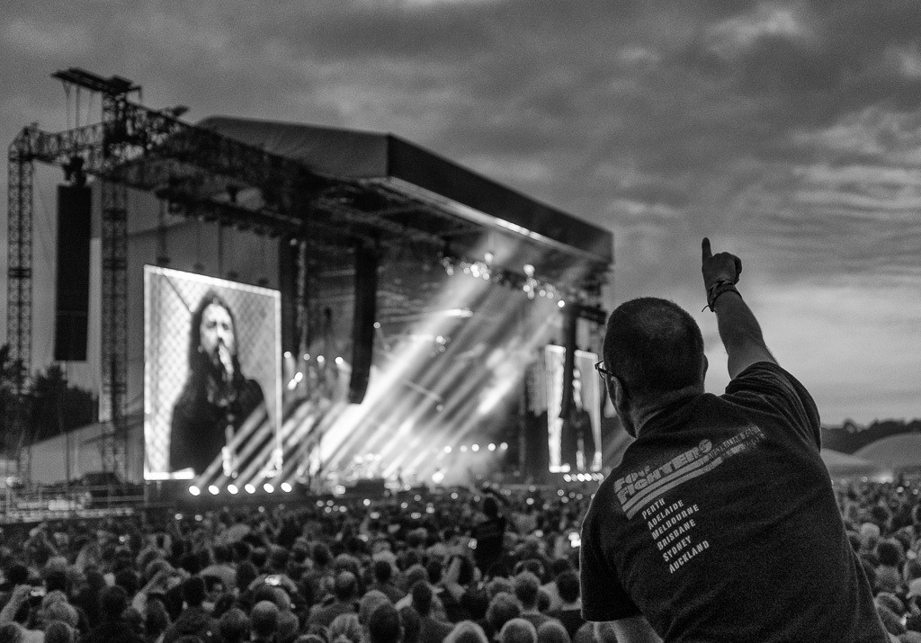 foo-fighters-2018-234 | Besucher beim Konzert der US-amerikanischen Rockband Foo Fighters auf der Trabrennbahn Hamburg-Bahrenfeld am 10. Juni 2018. Auf der Videowand ist der Bandgründer, Gitarrist und Sänger Dave Grohl zu sehen. - Realisiert mit Pictrs.com