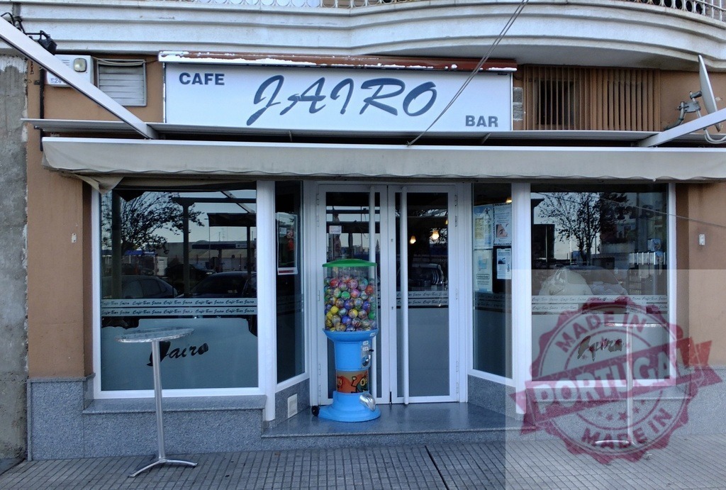 Cafe Bar Jairo storefront gumball machine exterior | Cafe Bar Jairo storefront with a gumball machine and outdoor tables - Realisiert mit Pictrs.com