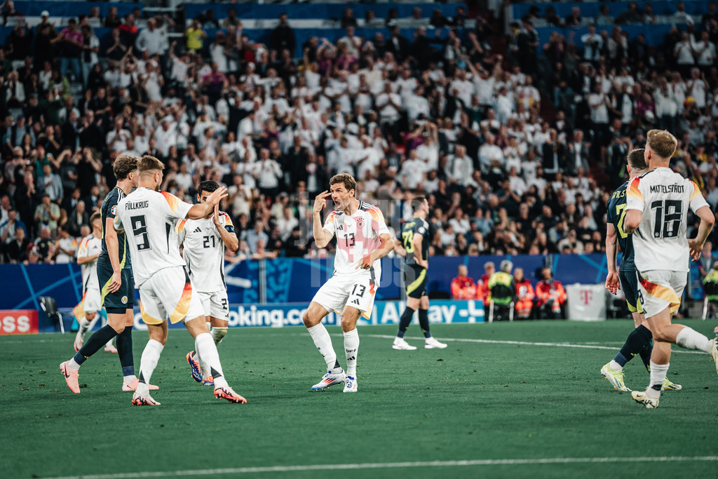 Fußball | Herren | UEFA-Fußball-Europameisterschaft 2024 | MD1 | Gruppe A | Deutschland vs. Schottland | 14.06.2024 | Thomas Müller (#13, Deutschland) mitte symbolisiert Niclas Füllkrug (#9, Deutschland) sein Zuspiel mit Auge