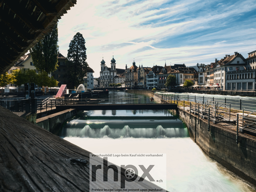 Das Luzerner Nadelwehr | Kraft. Technik. Tradition.Das historische Nadelwehr reguliert seit Generationen den Wasserstand des Vierwaldstättersees und prägt das Stadtbild von Luzern auf einzigartige Weise. Die Kombination aus rauschendem Wasser und der barocken Silhouette der Jesuitenkirche macht diesen Ort zu einem Symbol für die lebendige Geschichte der Stadt.Wähle unter "Produktauswahl" dein Wunschformat: Vom klassischen Wandbild über Puzzle &amp; Tassen bis zum digitalen Download (z.B. als Handy-Hintergrund). - Realisiert mit Pictrs.com