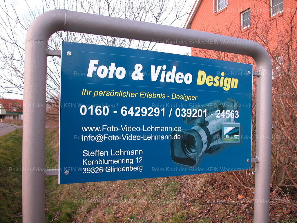 Werbeschild in Glindenberg_6172 | Mein erstes Firmenschild---Dieses Firmenschild stand vor meinem Mietshaus in Glindenberg. Es war klein, schlicht und doch bedeutete es für mich unendlich viel. Zum ersten Mal stand dort mein Name, meine Kontaktdaten und die Bezeichnung „Ihr persönlicher Erlebnisdesigner“.---Diesen Begriff hatte ich ganz bewusst gewählt. Ich wollte nicht einfach nur fotografieren oder filmen. Mein Ziel war es, die schönsten Erlebnisse meiner Kunden in einem persönlichen Film festzuhalten, die Aufnahmen sorgfältig zu schneiden und mit passender Musik zu einer bleibenden Erinnerung werden zu lassen.---Heute ist das selbstverständlich. Jeder hat ein Smartphone in der Tasche und filmt besondere Momente oft selbst. Als ich mich selbstständig machte, war das noch ganz anders. Hochwertige Foto- und Filmaufnahmen waren etwas Besonderes und wurden meist nur zu besonderen Anlässen erstellt. - Realisiert mit Pictrs.com
