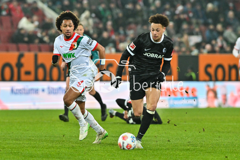 FC Augsburg - SC Freiburg | AUGSBURG, GERMANY - 18. JANUARY: im Duell Han-Noah MASSENGO (FC Augsburg 4) und Derry Lionel SCHERHANT (SC Freiburg 7) während dem Bundesligamatch zwischen dem FC Augsburg und dem SC Freiburg am 18. Spieltag in der WWK-Arena / DFL REGULATIONS PROHIBIT ANY USE OF PHOTOGRAPHS AS IMAGE SEQUENCES AND/OR QUASI-VIDEO