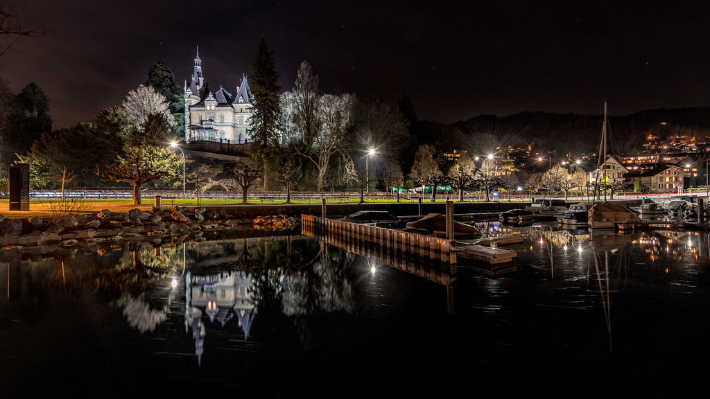 Schloss Hünegg | Nachtaufnahme vom Hafen Hilterfingen zum Schloss Hünegg mit einer schönen Wasserspiegelung. Am linken Bildrand ist die Klangskulptur <i>Wind Piece</i> der Künstlerin Danica Dakič zu sehen. 
------------------------------------------------------------
Night shot from Hilterfingen harbor to Hünegg Castle with a beautiful reflection of the water. The sound sculpture <i> Wind Piece </i> by the artist Danica Dakič can be seen on the left edge of the picture.
------------------------------------------------------------
Dieser Druck ist in einer limitierten Auflage von 5 Exemplaren erhältlich. 
This print is available in a limited edition of 5 copies. 
http://art.hess.photography/98-schloss-huenegg.html - Realisiert mit Pictrs.com