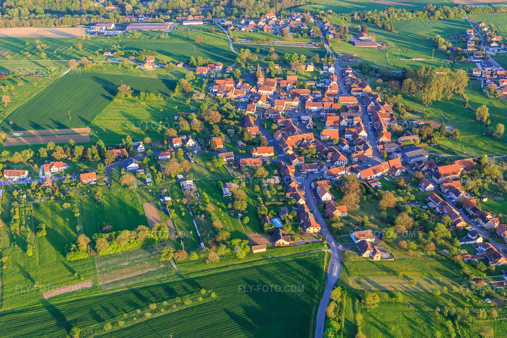 Aerial view: Village view from the northwest in Mackwiller in the state Bas-Rhin, France. – Photo: IMG_145871.jpg taken on 04/30/2025 by Werner Riehm/FLY-FOTO.com – Resolution of the original: 5472 x 3648 px