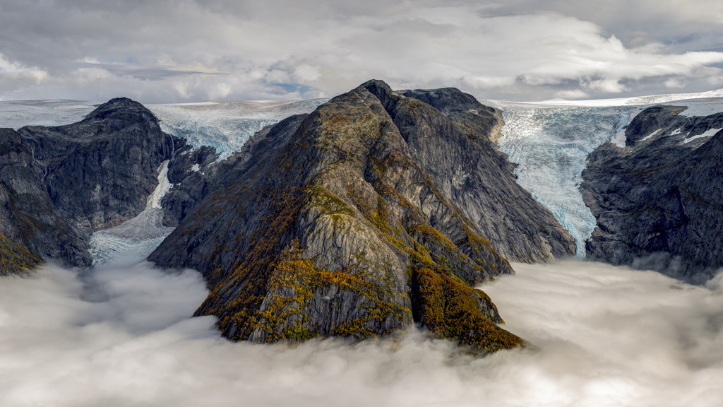 Brenndalsbreen und Briksdalsbreen über dem Nebelmeer | Die absolute Stille der norwegischen Bergwelt wird an den Gletschern von tiefem Grummeln durchbrochen. Der Moment, an dem der Gletscher kalbt und ein Stück Eis abbricht, macht uns klar, dass nicht wir hier die Regeln machen. - Realisiert mit Pictrs.com