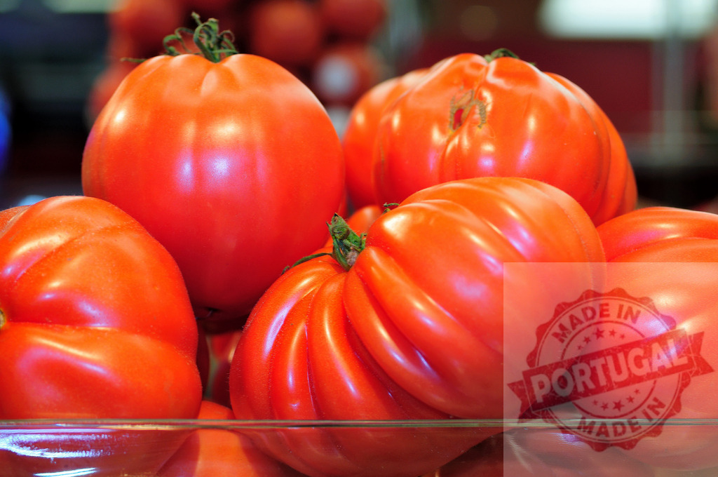 Fresh red organic heirloom tomatoes on display | Ripe heirloom tomatoes showing natural textures and vibrant colors - Realisiert mit Pictrs.com