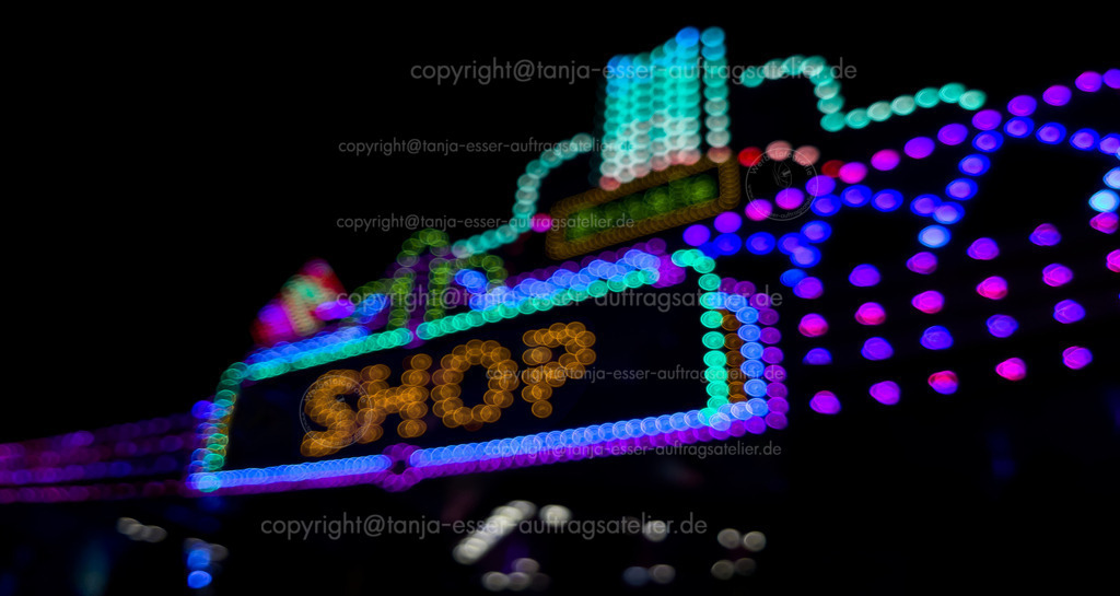Bokeh Schrift Shop D | Leuchtendes Schild mit englischem Text: Shop. Abends auf einer Feier oder einem Fest. Unscharfes Bokeh glitzert in diesem breiten Bild.