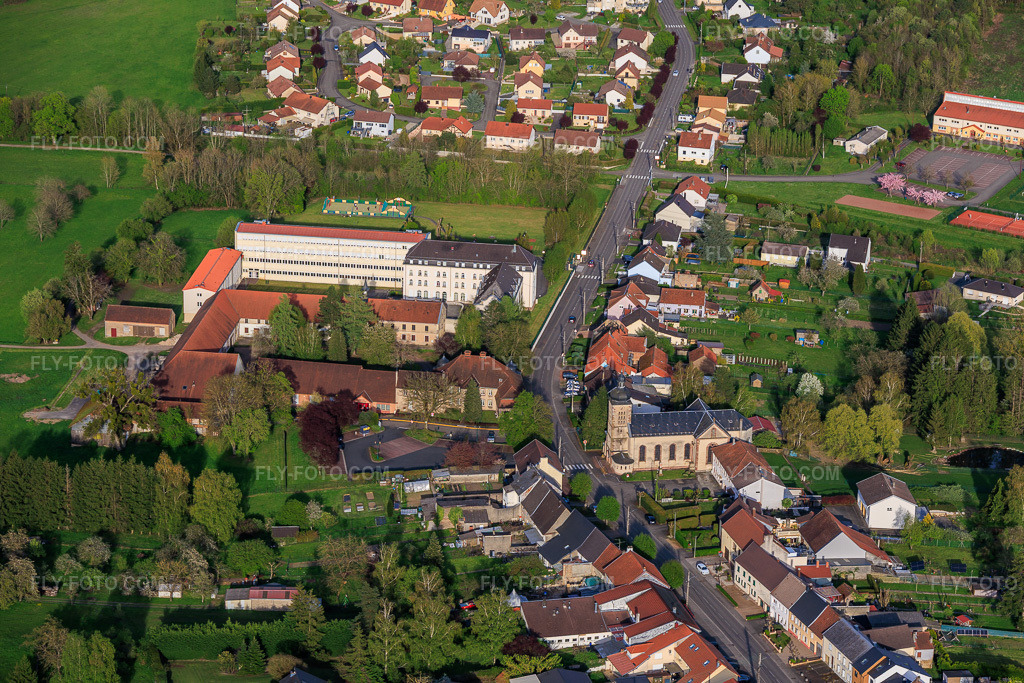 Aerial view: Clos du Chateau Festival Hall, Mayor's Office and Primary School in Neufgrange in the state Moselle, France. – Photo: IMG_154217.jpg taken on 04/17/2026 by Werner Riehm/FLY-FOTO.com – Resolution of the original: 5918 x 3945 px