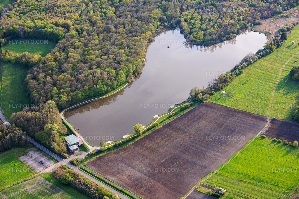 Aerial view: Fish pond Étang de Metzing and Salle Polyvalente L'Ecrin de Metzing at the edge of the forest in Metzing in the state Moselle, France. – Photo: IMG_154651.jpg taken on 04/17/2026 by Werner Riehm/FLY-FOTO.com – Resolution of the original: 6000 x 4000 px