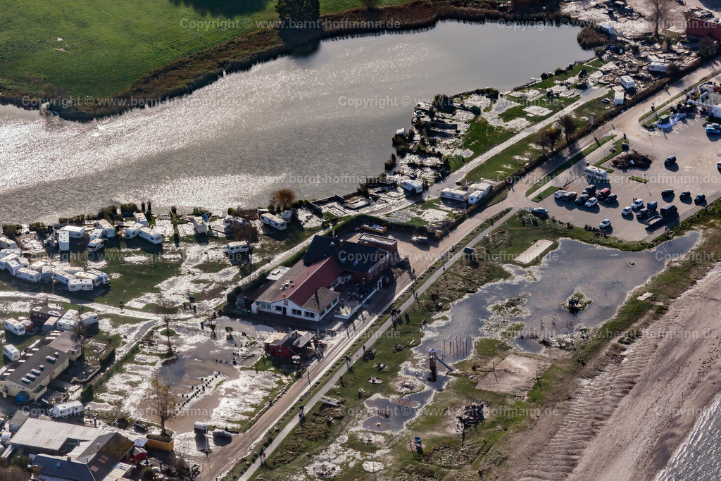 PLB_6565mod_Langballigau_105x70 | LUFTBILD. Langballigau - zerstörter Campingplatz. __ Überschwemmte Stellplätze und Gastronomie sowie Hotel -Infrastruktur. Im Gegenlicht der Nachmittagssonne glitzern die gefluteten Bereiche zwischen dem Strand und Wohnwagen - Stellplätzen am Binnensee. - Realisiert mit Pictrs.com