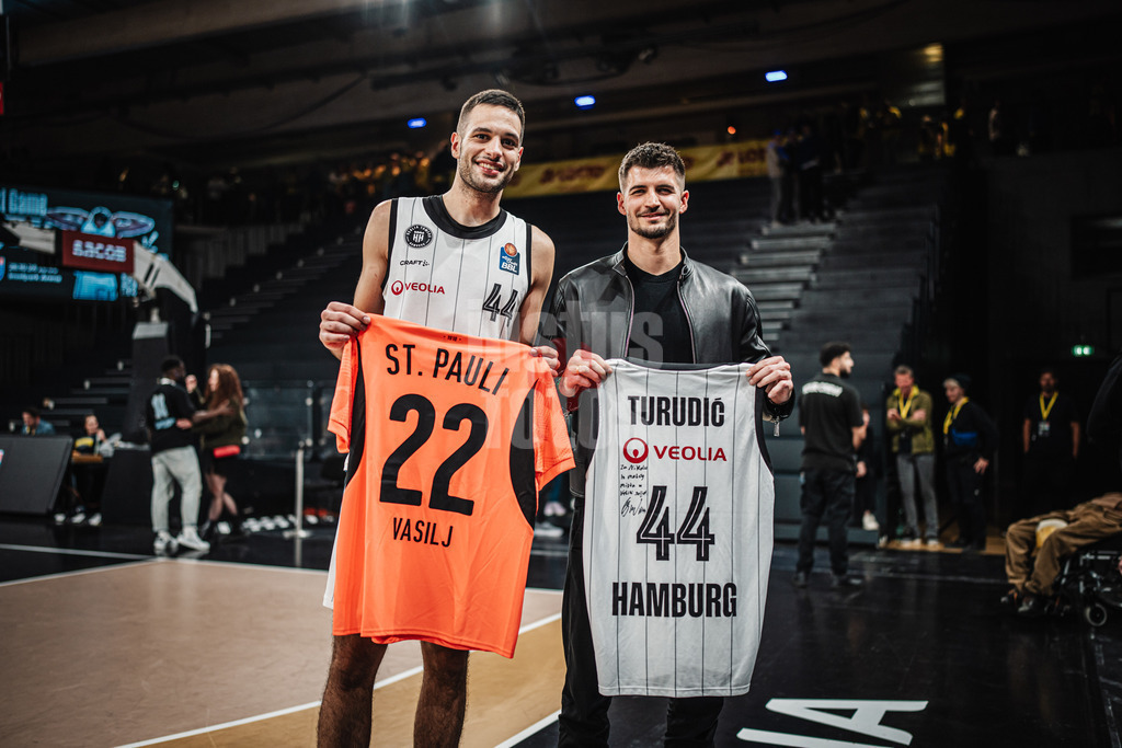 Basketball | Männer | Saison 2024/2025 | easyCredit Basketball Bundesliga | 4. Spieltag | Veolia Towers Hamburg vs. EWE Baskets Oldenburg | 06.10.2024 | v.l. Benedikt Turudic (#44, Veolia Towers Hamburg) und Nikola Vasilj (FC. St Pauli) Fußball beim Trikottausch