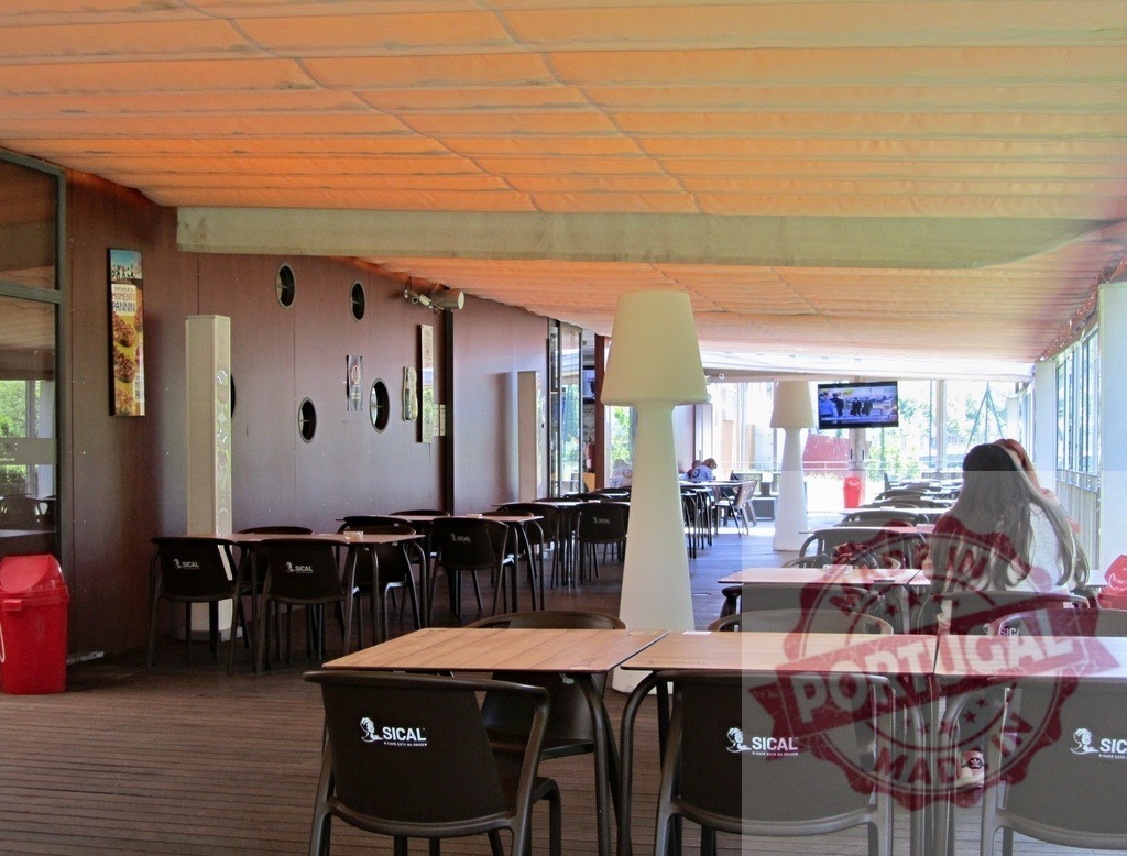 Modern cafe terrace with outdoor dining area | Outdoor patio setting with tables, chairs, people relaxing and watching television - Realisiert mit Pictrs.com