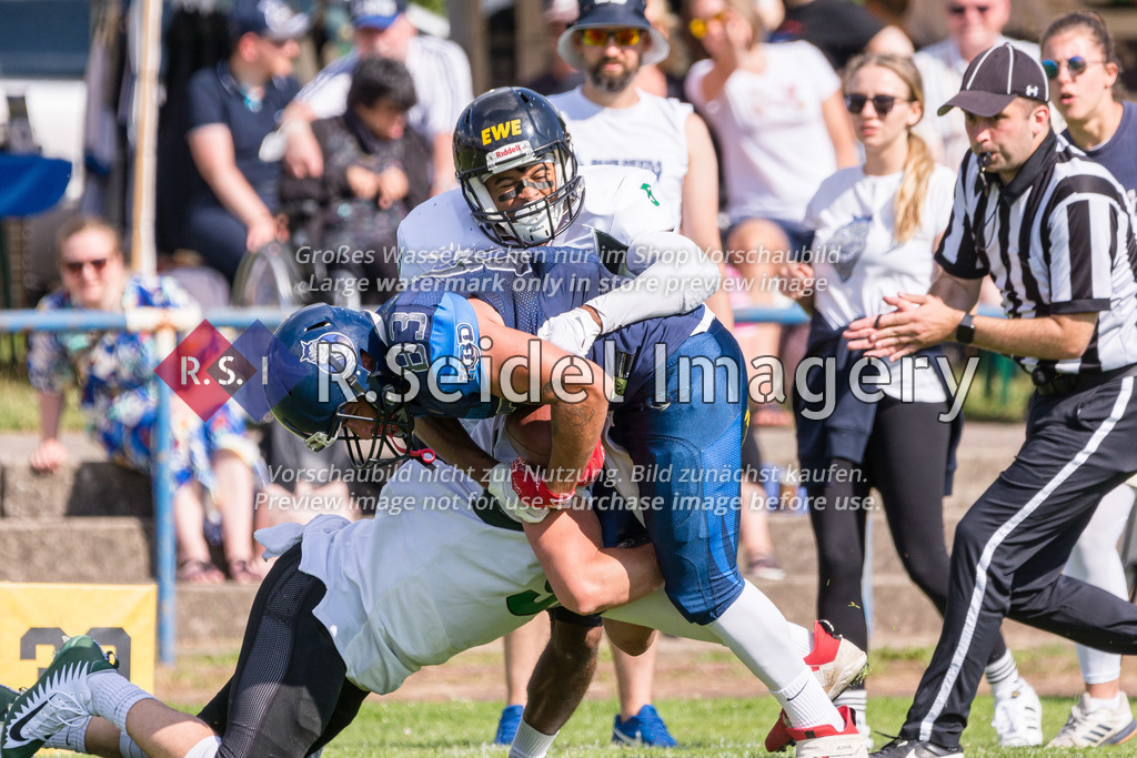 American Football, Saison 2022, Regionalliga Nord, Hamburg Blue Devils - Oldenburg Knights, Dr.-Hermann-Schnell-Sportplatz (Hamburg), 06.08.2022, 07. Gameweek | Jannik Birk (#91, Oldenburg, LB) und Ikenna Ukachu (#5, Oldenburg, DB, oben) tackeln Felix Maack (#83, Blue Devils, WR)