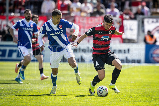 German 3rd Division, Viktoria Koeln vs. Energie Cottbus, 26.04.2026 | KOELN, GERMANY - APRIL 26, 2026:  King Manu (Energie Cottbus, 2) and Taylan Duman (FC Viktoria Koeln, 4) during the 3rd division match on gameday 35 between Viktoria Koeln vs. Energie Cottbus at the Sportpark Hoehenberg on April 26, 2026 in Koeln, Germany. DFL REGULATIONS PROHIBIT ANY USE OF PHOTOGRAPHS AS IMAGE SEQUENCES AND/OR QUASI-VIDEO.