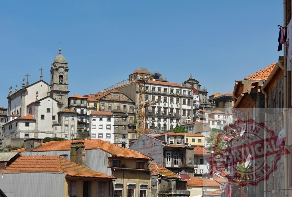 Porto cityscape with historical buildings and church. Porto - Portugal | Urban landscape of the Ribeira District showing traditional architecture and a church under blue sky - Realisiert mit Pictrs.com