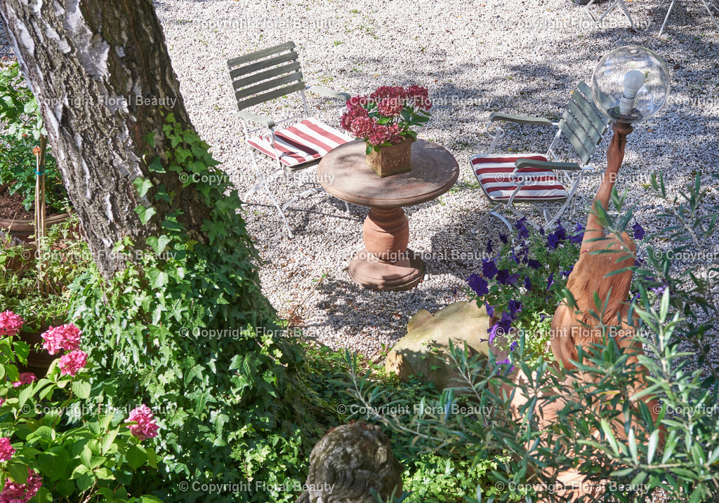 Mediterraner Stadtgarten | Städtischer Garten mit Treppenaufgang zum Balkon. Natursteintisch und Holzgartenstühle vor blühenden Hortensien. - Realisiert mit Pictrs.com