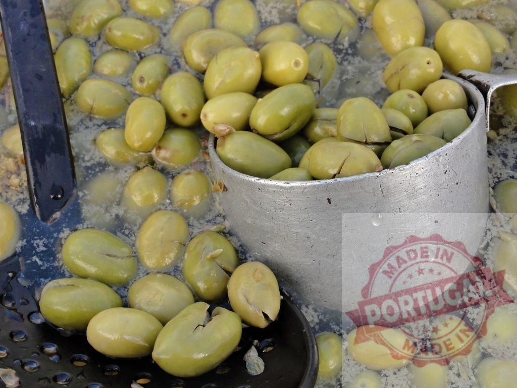 Green olives soaking in brine preparing for pickling | Green olives soaking in liquid brine, ready for sale at a market stall - Realized with Pictrs.com