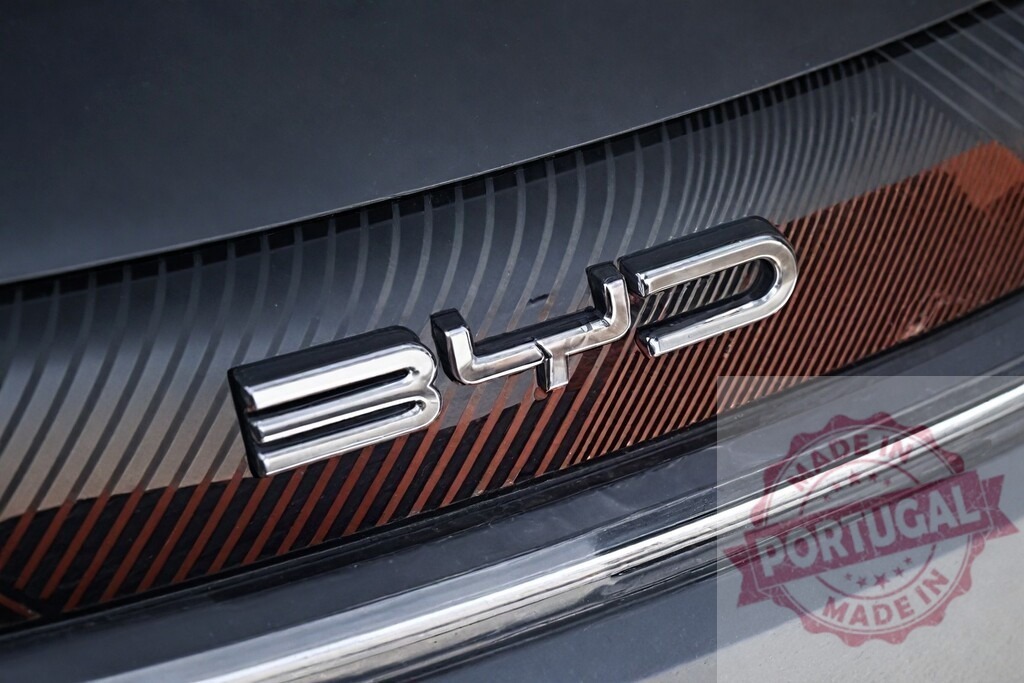 BYD car logo on electric vehicle grill | BYD chrome emblem on an electric car grill - Realized with Pictrs.com