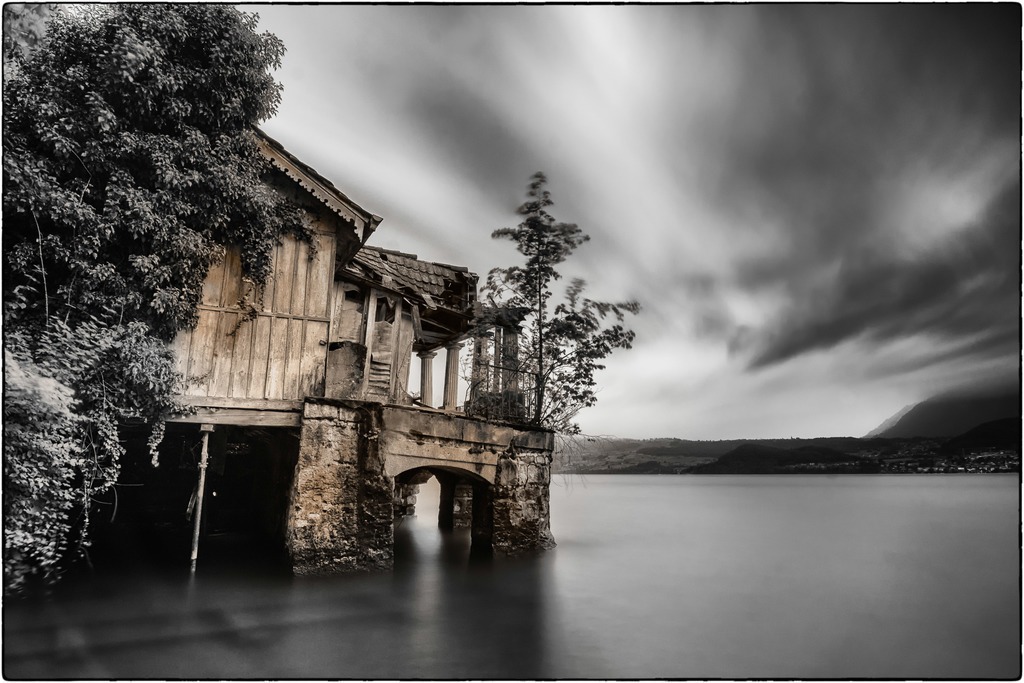 Gunten | Langzeitaufnahme eines verfallenden Bootshauses in Gunten am Thunersee. 
Die in Schwarzweiss konvertierte Aufnahme habe ich selektiv mit Sepia eingefärbt.
-------------------------------------------------------
Long exposure of a decaying boathouse in Gunten on Lake Thun.
I selectively colored the recording, which was converted into black and white, with sepia.
-------------------------------------------------------
Dieser Druck ist in einer limitierten Auflage von 5 Exemplaren erhältlich. 
This print is available in a limited edition of 5 copies. 
http://art.hess.photography/82-gunten.html - Realisiert mit Pictrs.com