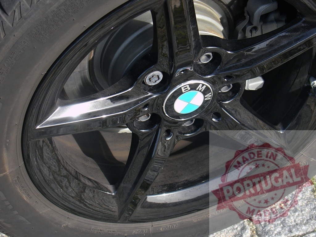 BMW car black alloy wheel detail outdoors | Closeup of a black BMW car wheel and tire outdoors on a sunny day - Realisiert mit Pictrs.com