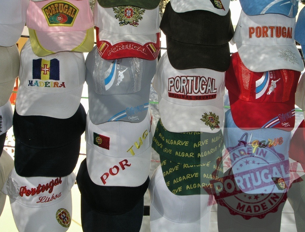 Portugal souvenir baseball caps displaying regional pride | Displaying a variety of baseball caps with Portugal, Madeira, Algarve, and Lisboa embroidery for tourists - Realized with Pictrs.com