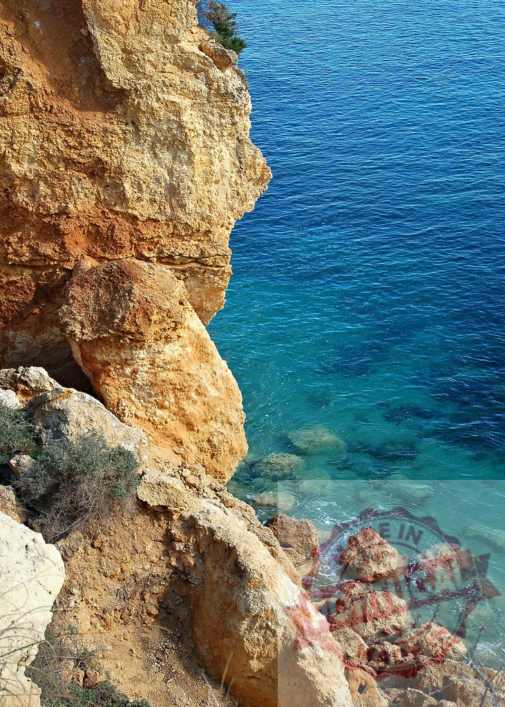 Rock cliff forming human face profile over azure sea | Coastline with rock formation resembling a face overlooking clear turquoise water - Realized with Pictrs.com