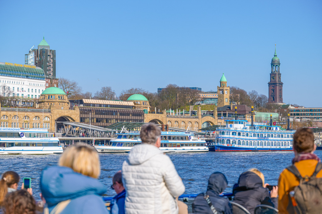 Hafenrundfahrt Landungsbrücken | Fahrgäste schauen von einem Schiff auf die Landungsbrücken in Hamburg. Eine Aufnahme bei strahlendem Sonnenschein im Winterhalbjahr. — Auflösung des Originals: 8256 x 5504 px. - Realisiert mit Pictrs.com