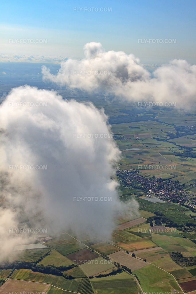 Aerial view: Village view under clouds from the north in Steinseltz in the state Bas-Rhin, France. – Photo: IMG_21007.jpg taken on 09/06/2009 by Werner Riehm/FLY-FOTO.com – Resolution of the original: 3019 x 4529 px