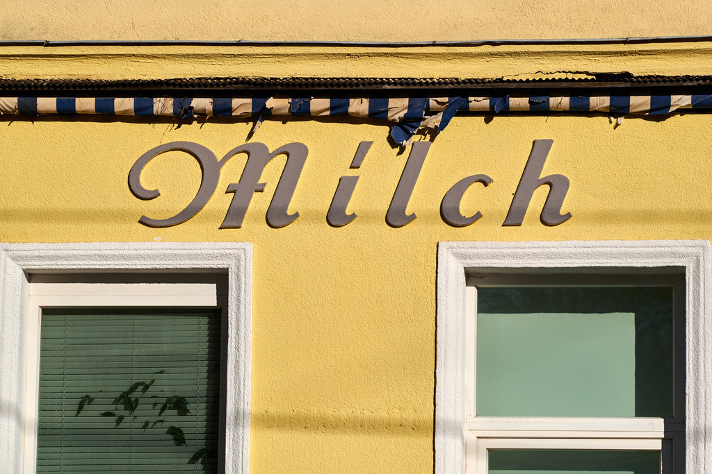 geschlossenes Verkaufslokal mit Aufschrift Milch | Wien, Austria - February 23, 2022: geschlossenes gelbes Verkaufslokal mit Aufschrift Milch. - Realisiert mit Pictrs.com