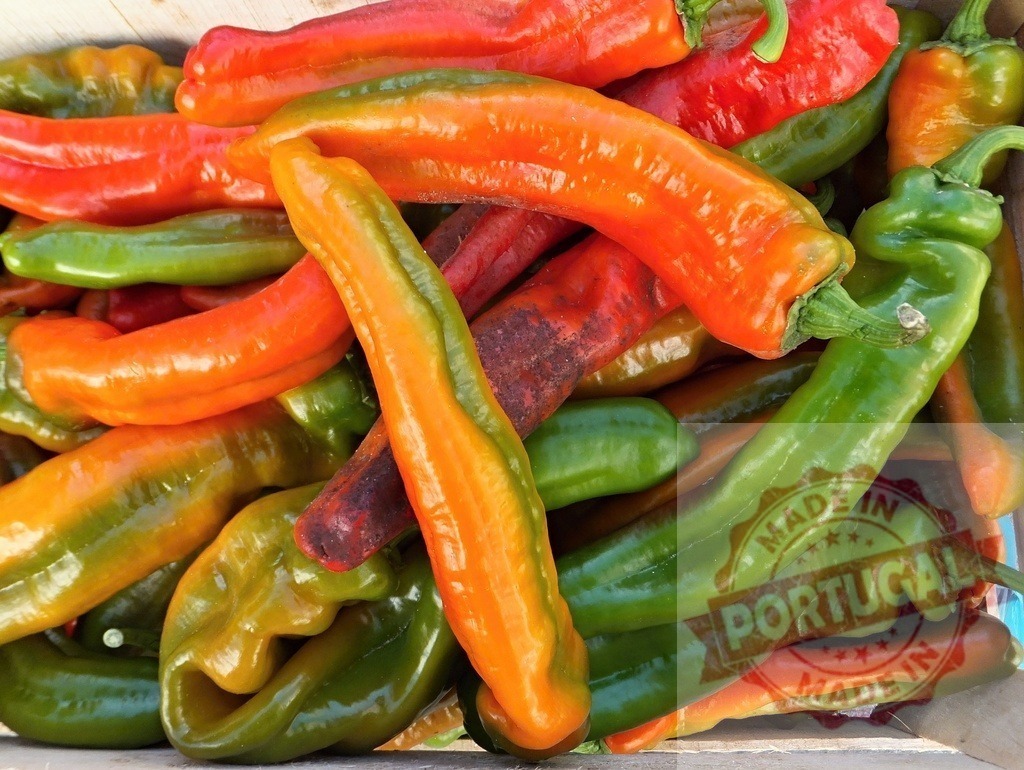 Colorful freshly harvested peppers in a wooden crate | Freshly picked red, green, and orange chili peppers piled in a rustic wooden crate - Realized with Pictrs.com