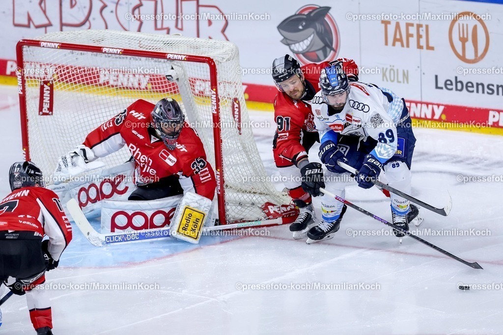 KEC1404251112 | 14.04.2025, Eishockey, DEL Play-offs, Kölner Haie - ERC Ingolstadt, Halbfinale Spiel 6, Lanxess-Arena Köln: Julius Hudacek (Kölner Haie #35) verteidigt zusammen mit Moritz Müller (Kölner Haie #91) im Zweikampf gegen Austen Keating (ERC Ingolstadt #89) 