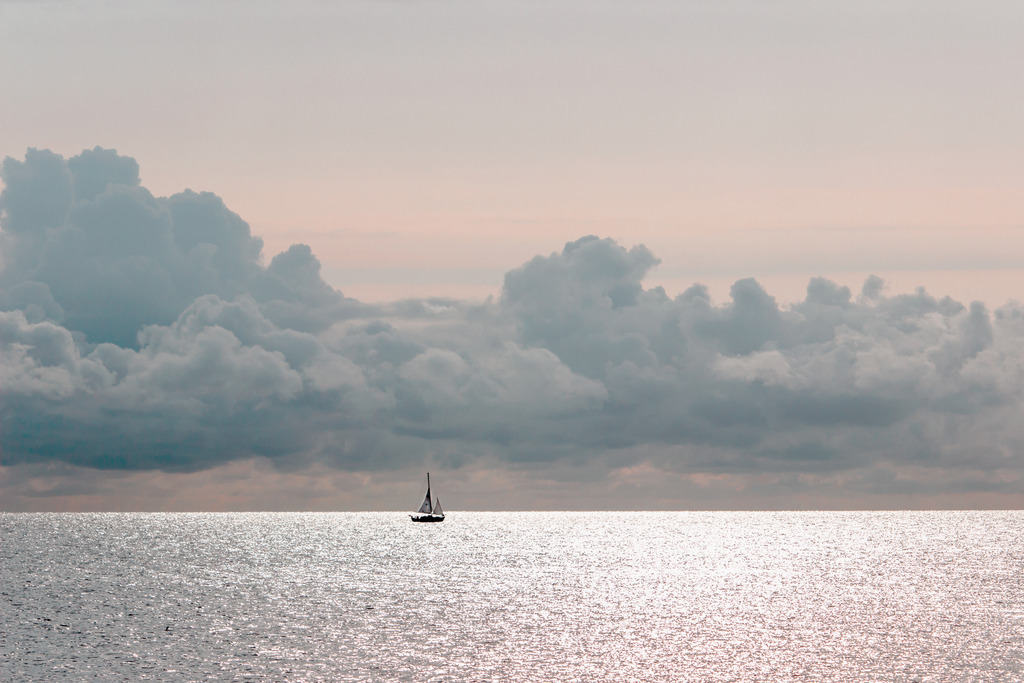 Wandbild: Segelboot und Wolken in dezenten Farben | Dieses Wandbild im Querformat zeigt das Meer in einer schönen morgendlichen Stimmung. In der Ferne kann man ein Segelboot im Sonnenschein auf der Ostsee erkennen. Am Himmel ist eine schöne Wolkenformation in unterschiedlichen Grau- und Rottönen zu sehen. Sie möchten Ihre Wände dezent aber stilvoll und elegant dekorieren? Dann holen Sie sich dieses maritime Wandbild. Es ist auf Leinwand, Aluminium-Platte, Acrylglas oder als Holzdruck erhältlich. Die Wandbilder werden individuell für Sie in vielen Abmessungen produziert. Daher passen die Ostseekult Wandbilder immer perfekt an Ihre Wände. - Realisiert mit Pictrs.com