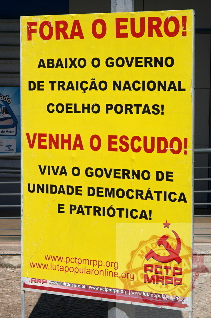 Portuguese communist party sign protesting Euro and government | Bright yellow sign showing political slogans against the Euro, calling for the return of the escudo - Realisiert mit Pictrs.com