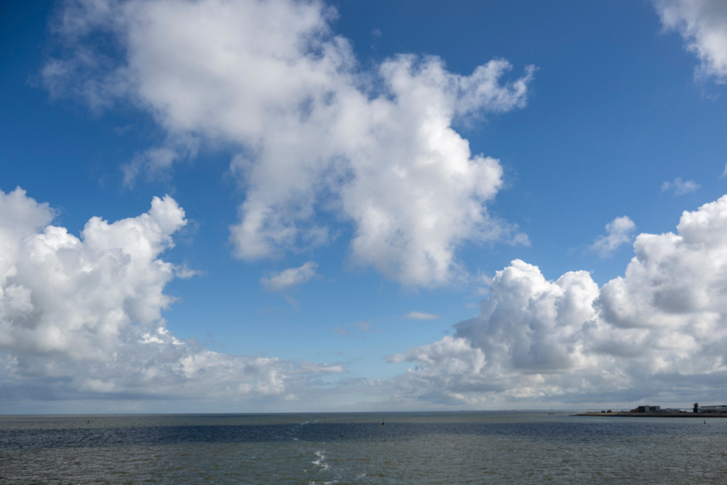 Grenzenlose Weite: Wo Himmel und Nordsee aufeinandertreffen | Ein tiefblauer Himmel über der Nordsee bei Texel, durchzogen von Strahlend weißen Kumuluswolken, weckt die Sehnsucht nach Freiheit und Meeresbrise. Das freie Spiel von Licht und Schatten auf der Wasseroberfläche fängt die unverfälschte Magie der holländischen Küste ein. Diese Aufnahme bringt das Gefühl von Ruhe, frischer Seeluft und endloser Natur direkt auf den Punkt – perfekt für Reiseberichte, emotionale Kampagnen und Naturmagazinstrecken. - Realisiert mit Pictrs.com