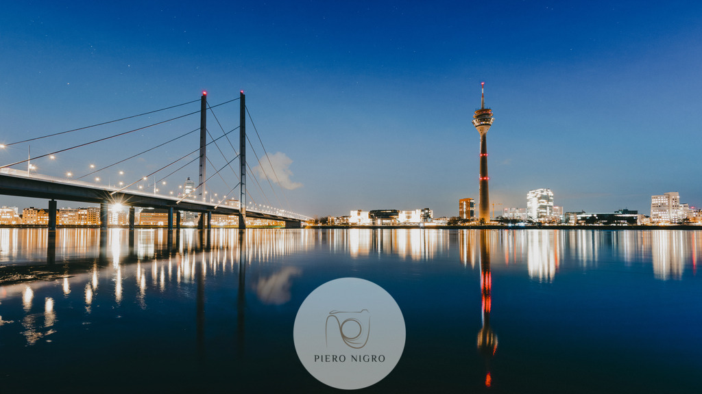 Düsseldorf Skyline Leinwanddruck - Moderne Wandkunst | Wallart | Wanddekot | DE: Unser Düsseldorf Skyline Leinwanddruck zeigt die atemberaubende Silhouette dieser deutschen Metropole, inklusive des imposanten Rheinturms und der ikonischen Rheinkniebrücke. Dieses hochwertige Kunstwerk wird auf Leinwand gedruckt und eignet sich hervorragend als zeitgemäße Wanddekoration. Die lebendigen Farben und die detailreiche Darstellung machen dieses Kunstwerk zu einem Blickfang in jedem Raum. Erwecken Sie die Schönheit Düsseldorfs in Ihrem Zuhause zum Leben und beeindrucken Sie Ihre Gäste. Perfekt für Wohnzimmer, Schlafzimmer, Büros und mehr. Ein absolutes Muss für alle Düsseldorf-Fans und Kunstliebhaber.

EN: Our Düsseldorf Skyline canvas print showcases the stunning silhouette of this German metropolis, including the impressive Rheinturm and iconic Rheinkniebrücke. This high-quality artwork is printed on canvas and makes for excellent contemporary wall decor. The vibrant colors and intricate detailing make this artwork a focal point in any room. Bring the beauty of Düsseldorf to life in your home and impress your guests. Perfect for living rooms, bedrooms, offices, and more. A must-have for all Düsseldorf enthusiasts and art lovers. - Realisiert mit Pictrs.com