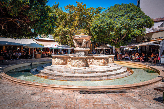 2026-07-20_10-27-08_960 | Kunstvoller Brunnen „Morosini-Brunnen“ auf dem Löwenplatz mit Löwenfiguren, umgeben von Cafés, Heraklion, Kreta, Griechenland - Realisiert mit Pictrs.com
